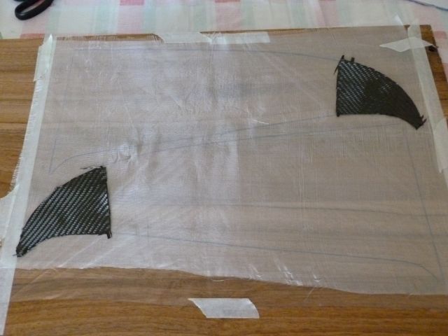 Sobre uma tábua, desenho com um gabarito o formato das asas.<br /><br />Então, estico um plástico para isolar a madeira. Por cima coloco o tecido de fibra de vidro e de carbono nas pontas.